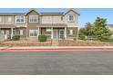 Charming multi-level townhome with two-tone siding, brick foundation, covered porch, and well-maintained landscaping at 14700 E 104Th Ave # 2802, Commerce City, CO 80022