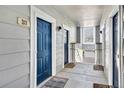 Hallway with neutral grey walls, contrasting blue doors, and views to the outside at 5255 Memphis St # 317, Denver, CO 80239