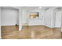 Open-concept living space with wood floors, white walls, and views of the kitchen at 5255 Memphis St # 317, Denver, CO 80239