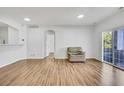 Bright living room with beautiful floors, a leather chair, and access to a balcony at 5255 Memphis St # 317, Denver, CO 80239