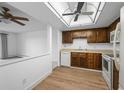 Cozy kitchen featuring wood cabinets, laminate countertops, and new flooring at 13850 E Marina Dr # 304, Aurora, CO 80014