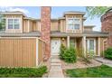 Charming townhouse showcasing the front door, complemented by green bushes and well-maintained landscaping at 14343 E Dickinson Dr # E, Aurora, CO 80014