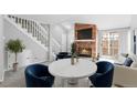 Bright living room features modern furniture, including blue chairs, fireplace, and stairs to the upper level at 14343 E Dickinson Dr # E, Aurora, CO 80014