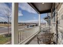 Inviting covered porch featuring comfortable seating and views of the neighborhood and distant mountains at 6905 Fraser Cir, Frederick, CO 80530