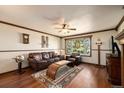 Inviting living room with beautiful hardwood floors, large window, and a ceiling fan at 8210 W 72Nd Pl, Arvada, CO 80005