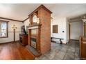 Stylish living room with a fireplace and tile flooring flowing into a connected hallway at 8210 W 72Nd Pl, Arvada, CO 80005