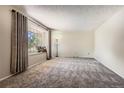 Bright living room with big window, carpeted flooring, neutral wall color and natural light at 10247 W Arkansas Ave, Lakewood, CO 80232