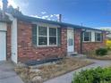 Close up of brick home with green shutters and a white front door at 2617 S Cimarron St, Aurora, CO 80014