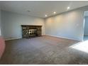 Large living room featuring plush carpet, stone fireplace, and natural light at 2617 S Cimarron St, Aurora, CO 80014
