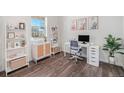 Bright home office with stylish decor, a modern desk setup, and large windows offering neighborhood views at 7415 E 158Th Pl, Thornton, CO 80602