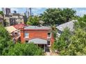 Aerial view of a brick home surrounded by lush greenery, showing the rooftop and neighboring buildings at 2227 N Ogden St, Denver, CO 80205