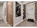 Inviting entryway with a decorative wall mirror, light hardwood floors, and an elegant patterned wallpaper at 14111 Blue Stem St, Broomfield, CO 80020