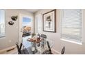 Bright dining nook featuring a modern glass table and natural light from a door and window at 13616 E 103Rd Pl, Commerce City, CO 80022