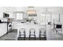 Modern kitchen with white cabinets, quartz countertops, stainless steel appliances, and a kitchen island at 1561 W Beekman Pl, Denver, CO 80221