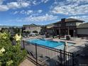 The community pool features lounge seating and a pergola with an outdoor cooking area at 15274 W 64Th Ln # 206, Arvada, CO 80007