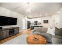 An open-concept living room showcases a decorative chandelier and flows into a modern kitchen at 15274 W 64Th Ln # 206, Arvada, CO 80007