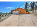 A bright, oversized garage featuring a large driveway and ample parking space with mountain views at 22349 Natsihi Rd, Indian Hills, CO 80454