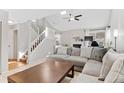 Bright living room with large sofa, fireplace, and stairs to the upper level at 944 E Lily Ct, Highlands Ranch, CO 80126