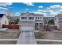 Two-story home with brick accents, attached two car garage and a well-maintained front yard and landscape at 18668 E Vassar Dr, Aurora, CO 80013