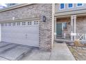 Charming home featuring a gray brick exterior, two-car garage, and welcoming front porch at 18668 E Vassar Dr, Aurora, CO 80013