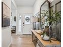 Inviting foyer with hardwood floors, decor table and large framed mirror at 693 Penn Rd, Elizabeth, CO 80107