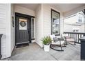 Inviting front porch featuring rocking chairs, stylish black door frame, and classic paneled walls at 693 Penn Rd, Elizabeth, CO 80107