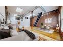 Spacious living room with exposed brick, hardwood floors, skylights, and industrial-style details, bathed in natural light at 1510 Wazee St # 3, Denver, CO 80202
