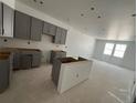 A bright kitchen with grey cabinets and an island is under construction, promising a modern design at 17117 W 91St Ln, Arvada, CO 80007