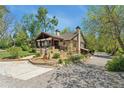 Landscaped yard surrounding a charming home with stone accents, a welcoming porch, and mature trees at 740 Carr St, Lakewood, CO 80214