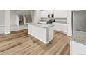 Bright kitchen with granite counters, a center island, and stairs leading up at 2120 Christina St, Fort Lupton, CO 80621