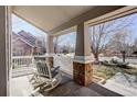 View of the front porch with brick-based pillars and rocking chairs, offering a relaxing outdoor space at 14032 Park Cove Dr, Broomfield, CO 80023