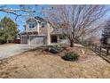 Beautifully landscaped front yard with a large tree, shrubs, and a well-maintained lawn at 14032 Park Cove Dr, Broomfield, CO 80023