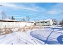 Large backyard with snow, partially fenced at 6661 Clermont St, Commerce City, CO 80022