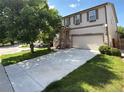 Charming two-story home featuring an inviting front yard and a spacious driveway leading to a two-car garage at 20401 E Chenango Pl, Aurora, CO 80015