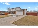 Traditional two-story home featuring a covered front porch, an attached two-car garage and driveway at 9135 Bellaire St, Thornton, CO 80229