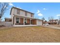 Inviting two-story home boasting a covered front porch with seating and a well-maintained lawn at 9135 Bellaire St, Thornton, CO 80229