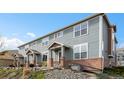 Charming townhome featuring blue siding, brick accents, and well-maintained landscaping at 8251 W 54Th Ave # 4, Arvada, CO 80002