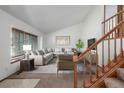 Bright living room featuring vaulted ceilings, a large window, and staircase with wooden banister at 18083 E Atlantic Dr, Aurora, CO 80013