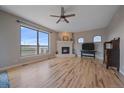 Bright living room featuring a tile fireplace, hardwood floors and a large window at 575 Howling Cir, Elizabeth, CO 80107