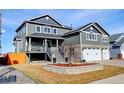 Gray two-story home with stone accents, landscaped yard, and covered porch at 5895 E Conservation Dr, Frederick, CO 80504