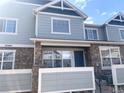 Inviting townhome featuring stone accents, blue siding, and a well-manicured front yard at 23465 E Platte Dr # C, Aurora, CO 80016