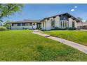 Beautifully landscaped front yard with a stone walkway leading to a modern home featuring a unique bay window and stylish exterior paint at 6220 E 5Th Ave, Denver, CO 80220