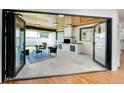 Charming outdoor patio with a brick fireplace, comfortable seating, and folding glass doors to seamlessly integrate indoor and outdoor spaces at 6220 E 5Th Ave, Denver, CO 80220