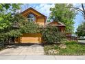 Charming two-story home featuring vibrant yellow siding, red trim, and mature landscaping at 3201 W 126Th Ave, Broomfield, CO 80020