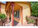 Cozy front porch featuring vibrant yellow siding, red trim, and a view of the garden at 3201 W 126Th Ave, Broomfield, CO 80020