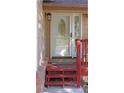 Close up of the front door with an oval glass design and a vibrant red porch at 7490 W Coal Mine Ave # A, Littleton, CO 80123