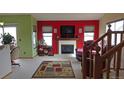 Cozy living room with a fireplace, red accent wall, and visible staircase at 7490 W Coal Mine Ave # A, Littleton, CO 80123