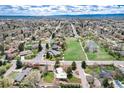 A stunning aerial view showcasing a peaceful neighborhood, a large park with a pond, and the home's position at 100 Balsam St, Lakewood, CO 80226
