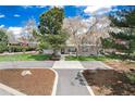 Expansive home featuring a well-manicured front yard, and a symmetrical walkway, complemented by lush trees at 100 Balsam St, Lakewood, CO 80226