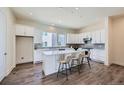 Modern kitchen with white cabinets, marble counters, an island with seating and stainless steel appliances at 682 Belay St, Erie, CO 80516